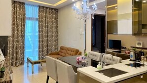 A modern kitchen with a dining area, a chandelier, and a large window with curtains. - Dorsett Residence KL by Nana's Boutique Suite (Kuala Lumpur)