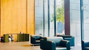 A lobby with a reception desk, seating area, and large windows. - Dorsett Residence KL by Nana's Boutique Suite (Kuala Lumpur)