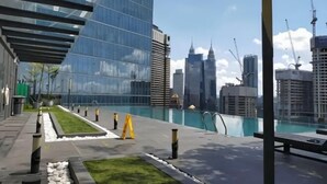 A rooftop pool with a city view, modern buildings, and a clear sky. - Dorsett Residence KL by Nana's Boutique Suite (Kuala Lumpur)