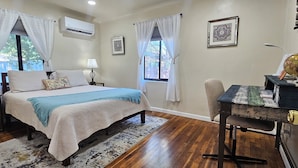 A bedroom with a bed, bedside tables, a desk with a globe, and a window with curtains.