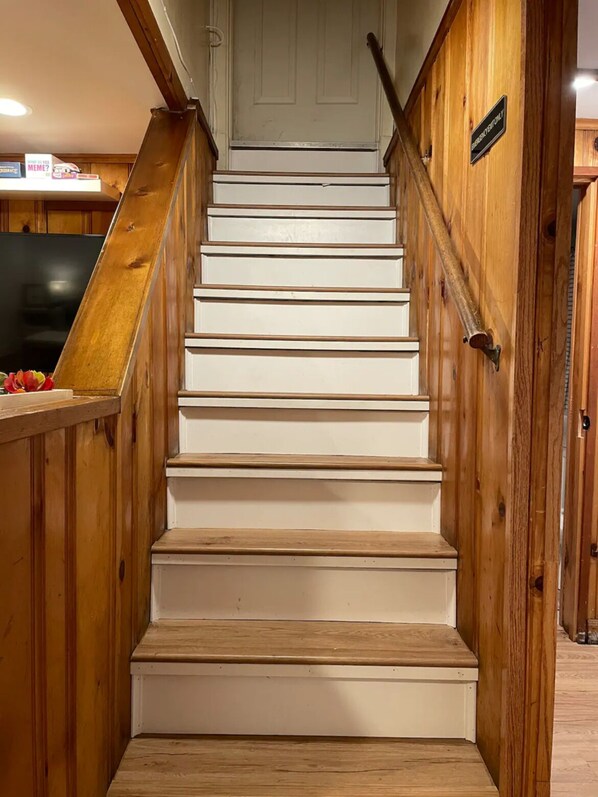 A wooden staircase with white steps leading to a door. - private 3 bedroom garden apartment in Lincoln square Chicago (Chicago)