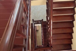 Una scala in legno con corrimano e uno specchio in cima.