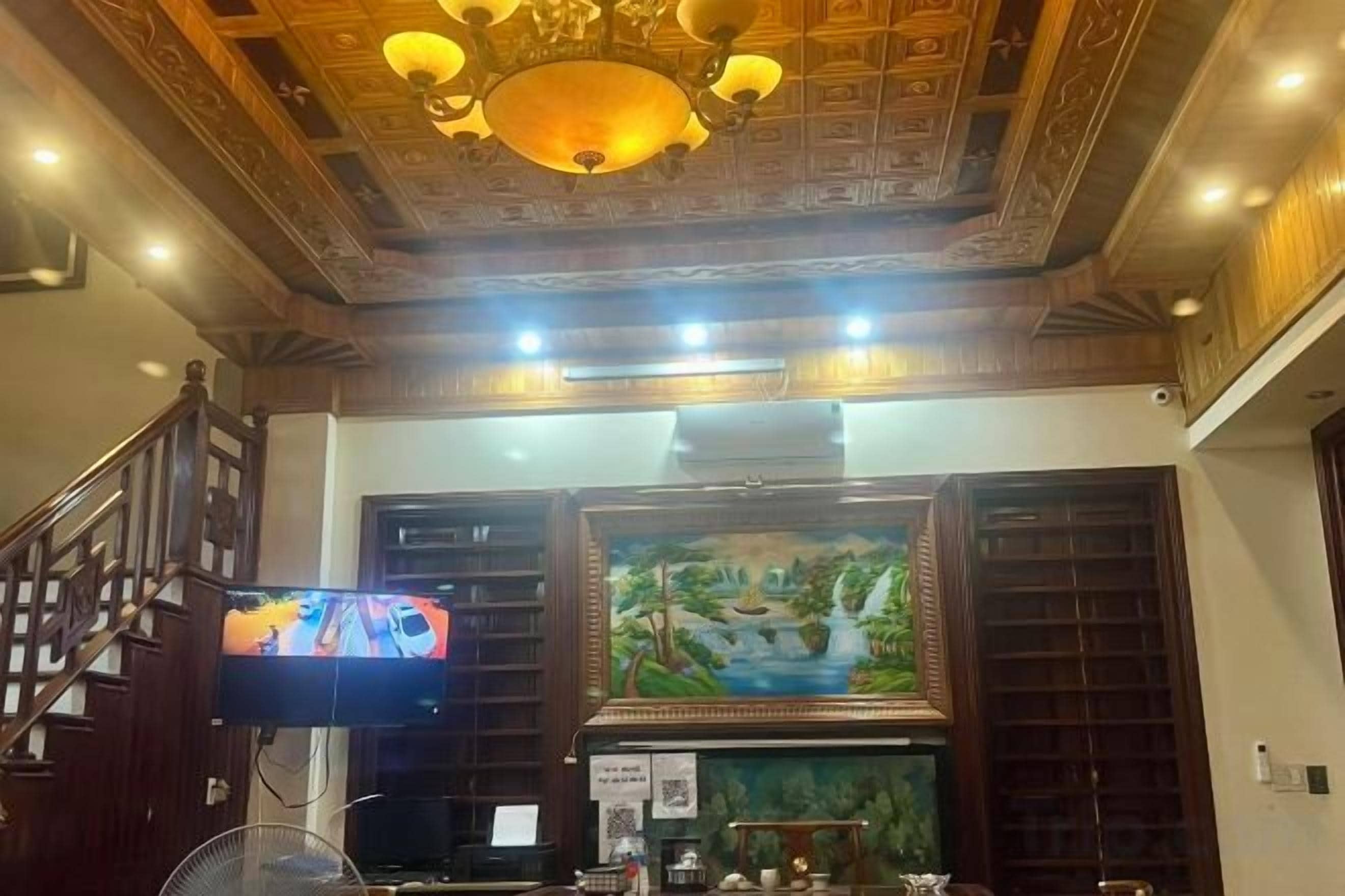 A hotel lobby with a wooden ceiling, a television, and a painting.