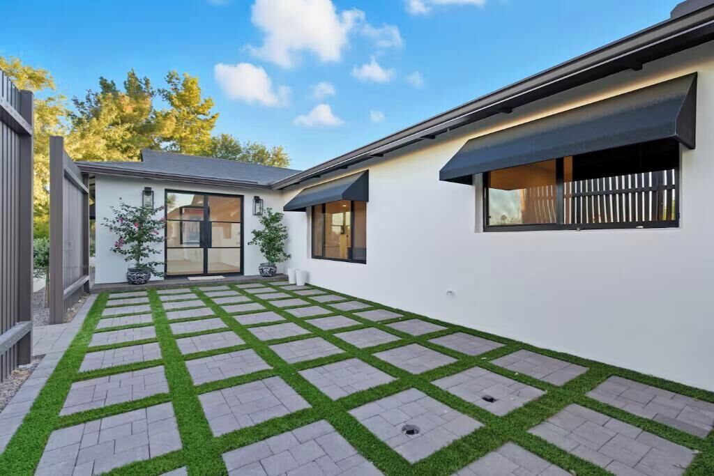 Ein modernes Haus mit gepflasterter Terrasse und kleinem Garten.