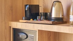 Una cocina compacta con microondas integrado y cafetera sobre una encimera de madera.