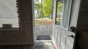 A wooden interior with a door leading outside, a welcome mat, and a window with blinds. - Great room w/ pool table in a 1-bdrm party barn in Newaygo; River access (Newaygo)
