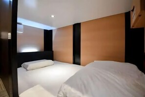 A hotel room with a bed, a nightstand, and a wall-mounted light fixture. - Male Only H2O Stay Ōtorii (Tokyo)