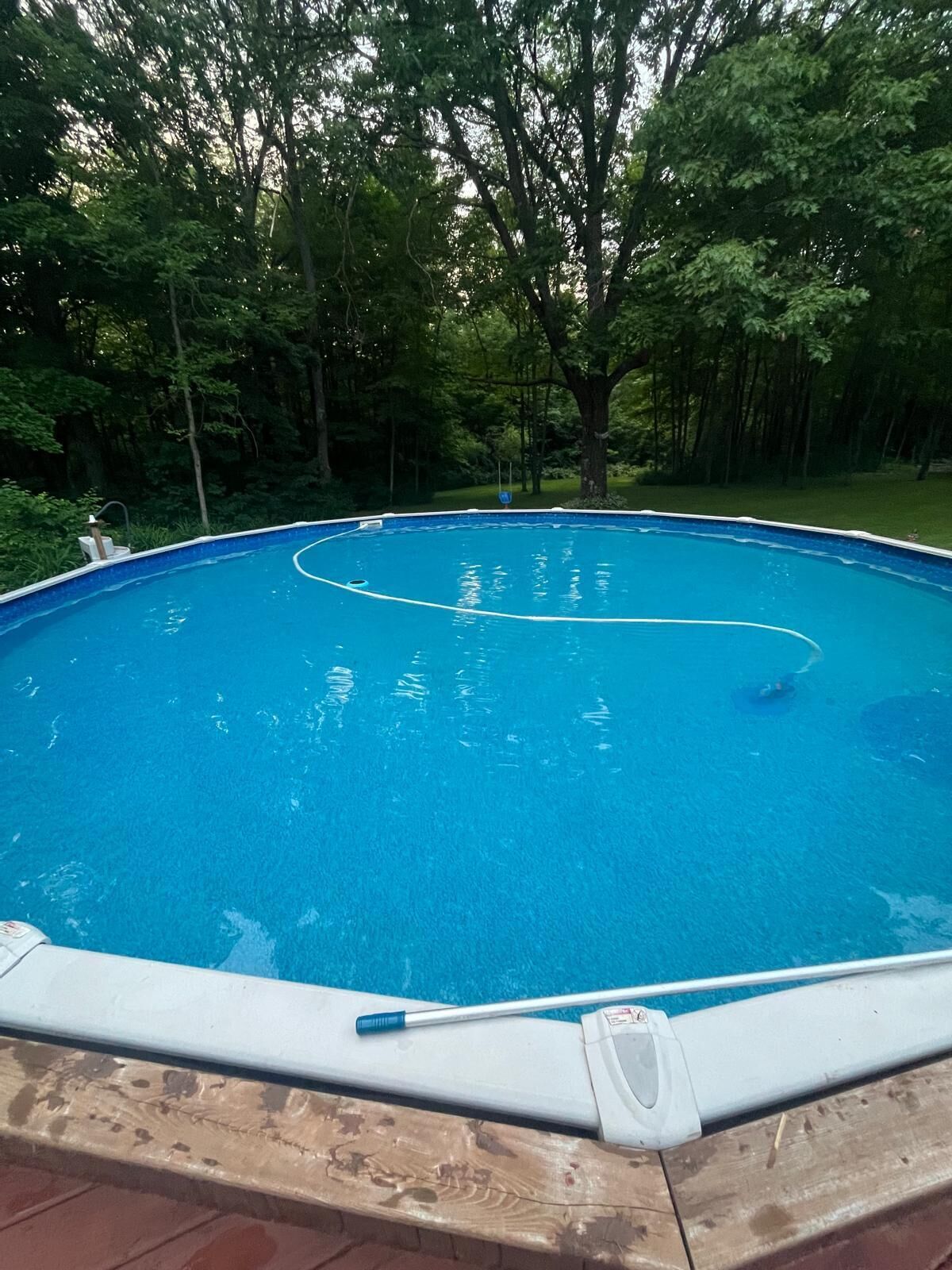Ein rechteckiger Pool mit weißem Rand, umgeben von einer Ziegelterrasse.