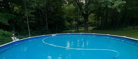 Ein rechteckiger Pool mit weißem Rand, umgeben von einer Ziegelterrasse.