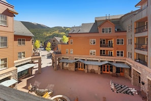 A multi-story building with a courtyard, stone pillars, and a checkered outdoor area. - Bl8352-2 (Keystone)