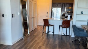 Una cocina moderna con piso de madera oscura, una isla central y armarios oscuros.