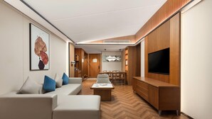 A modern living room with a sofa, coffee table, and TV. - Wingate By Wyndham Puer Tea Horse Ancient Town (Baoding)