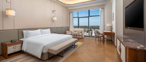 Una habitación de hotel moderna con una cama grande, un escritorio, un televisor y vistas a la ciudad.
