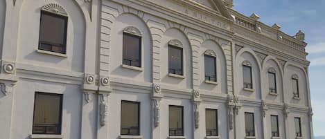 Un edificio clásico con ventanas arqueadas y molduras decorativas.