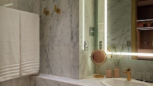 A bathroom with a marble sink, a round mirror, and a towel rack. - Horoh Grand Hotel (Cuiabá)