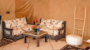 Ein Zimmer mit einer Couch, einem Couchtisch, einer Leiter und einem weißen Hocker.
