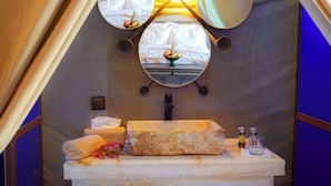 Ein Badezimmer mit Marmorwaschbecken, einem Spiegel und einem Handtuchhalter.