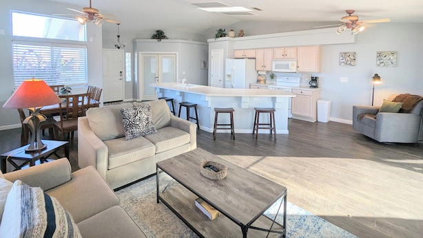 A modern open-plan living and kitchen area with a dining table, sofa, and a coffee table.