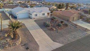 A residential area with houses, a driveway, and a mountain range in the background.