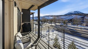 Ein Balkon mit Blick auf eine verschneite Landschaft und einen Berg.