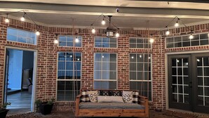 A brick exterior with multiple windows and a wooden bench in the center. - Beautiful Custom 4 bed with pool home with 3 acres. Private spacious backyard. (Campbell)