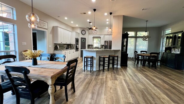 A spacious kitchen with a central island, wooden flooring, and pendant lighting. - Beautiful Custom 4 bed with pool home with 3 acres. Private spacious backyard. (Campbell)