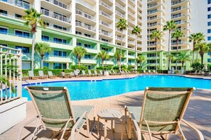 Un hôtel doté d’une piscine, de chaises longues et de palmiers.
