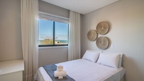 Una camera d'albergo con un letto, una scrivania e vista sul mare.