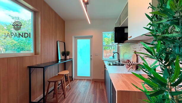A modern kitchen with wooden cabinets, a black countertop, and a large window. - Studio JAPANDI in wonderful Miami with AC (Miami)
