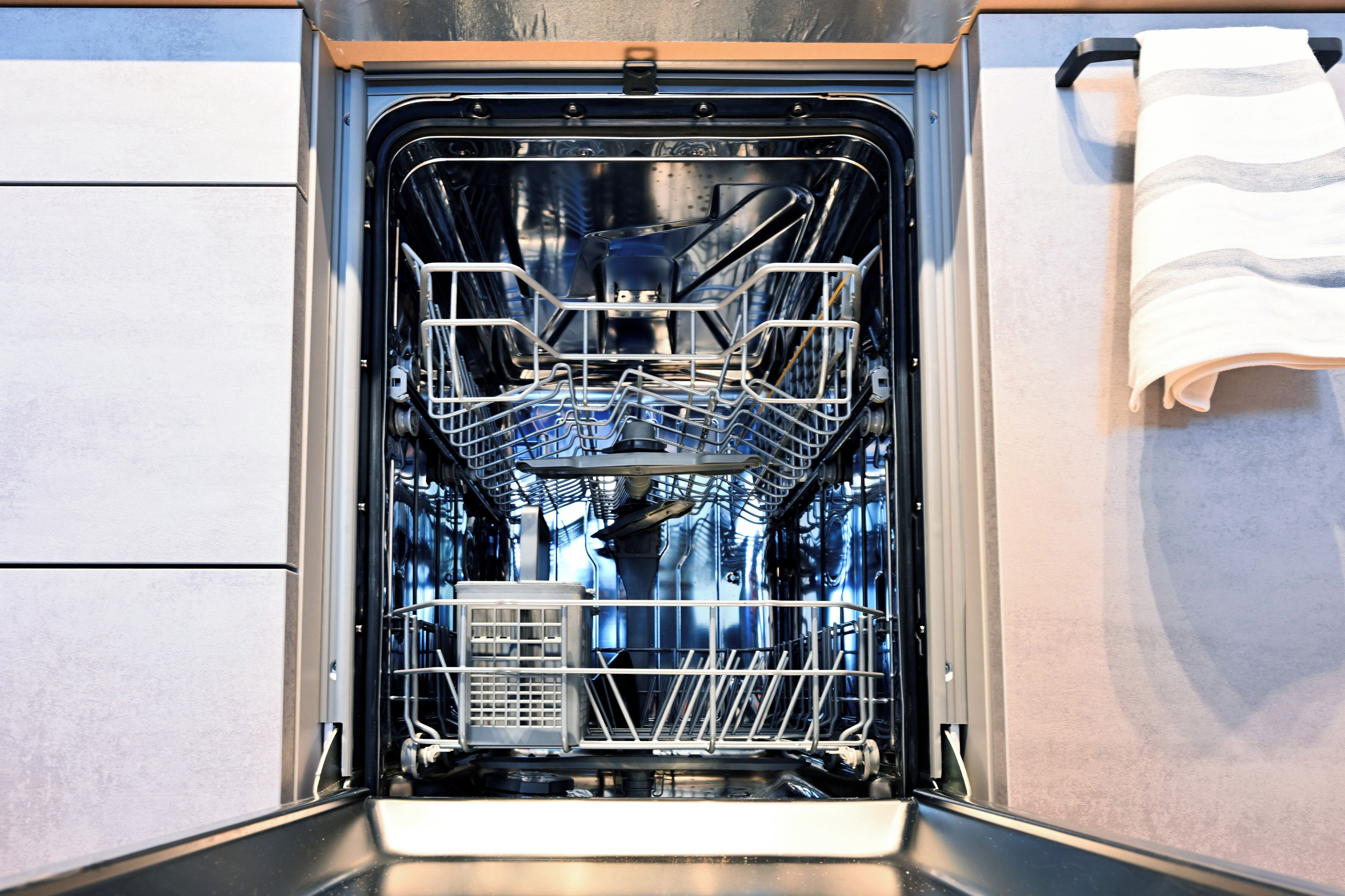 An open dishwasher with racks and utensils inside.