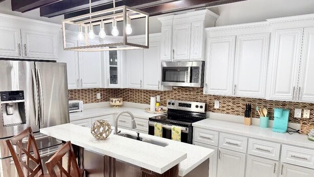 A modern kitchen with white cabinets, stainless steel appliances, and a central island. - GORGEOUS HOME, COURTYARD, LANDSCAPPED, ABOVE GROUND POOL ,Outside barbecue area. (McAllen)