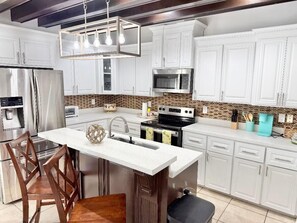 A modern kitchen with white cabinets, stainless steel appliances, and a central island. - GORGEOUS HOME, COURTYARD, LANDSCAPPED, ABOVE GROUND POOL ,Outside barbecue area. (McAllen)