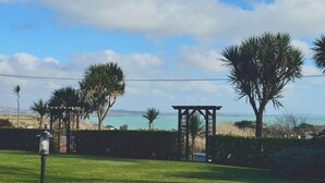 A grassy area with a gazebo, palm trees, and a view of the ocean. - Gorgeous traditional stone one bedroom cottage; A haven of tranquility in Goleen (Goleen)