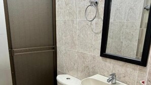 A bathroom with a toilet, sink, and a mirror. - HOTEL AVENIDA 15 (Melgar)