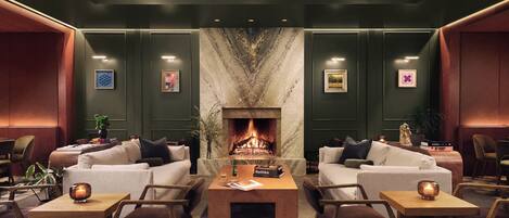 A cozy lounge area with a fireplace, comfortable seating, and a modern design.