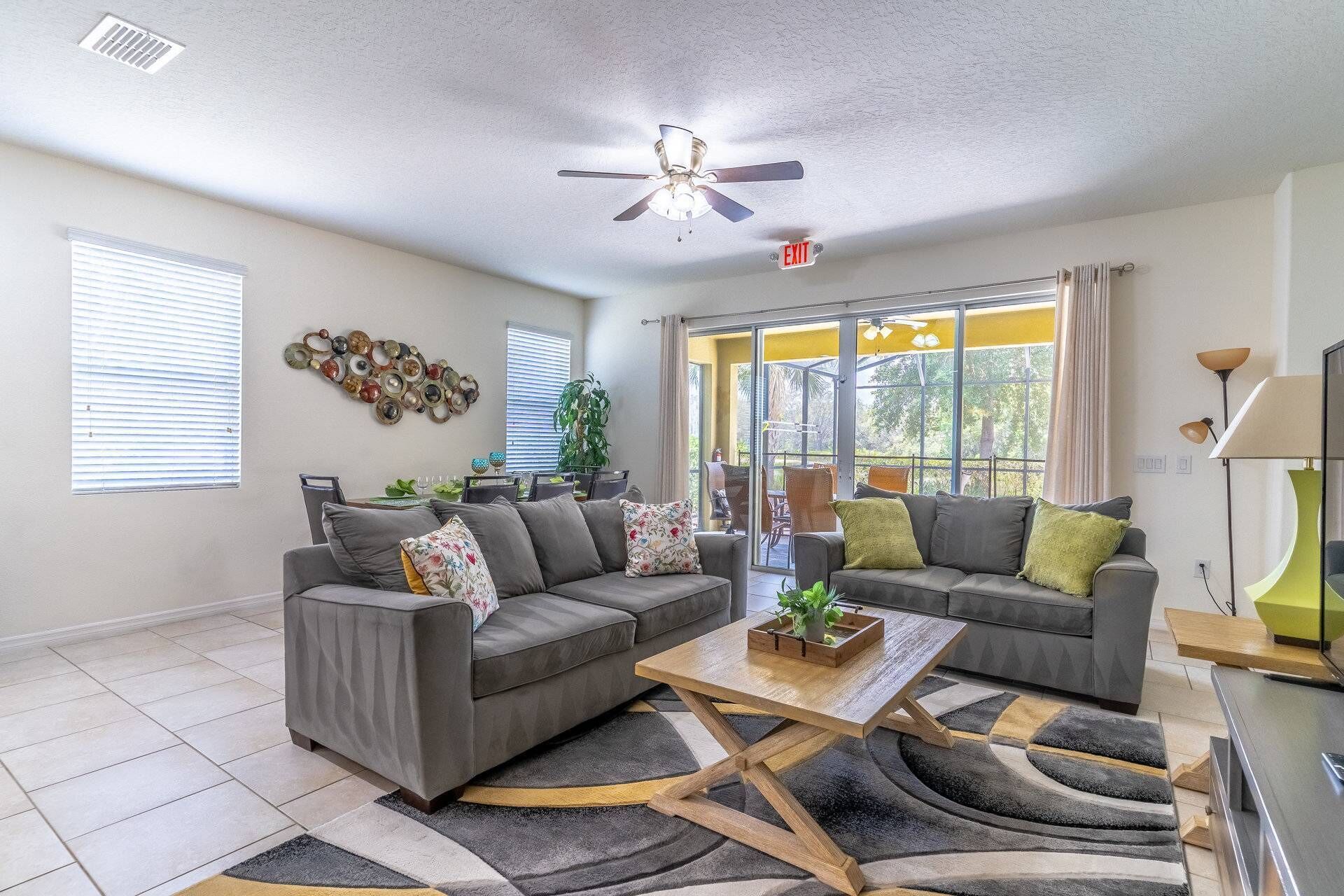 A modern living room with two grey sofas, a wooden coffee table, and a patterned rug.