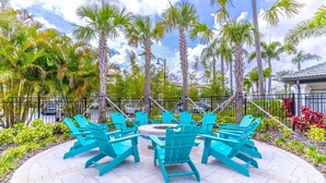 A round table with turquoise chairs in an outdoor setting surrounded by palm trees. - 4001 Vista Cay (Orlando)