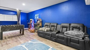 A room with a foosball table, a couch, and arcade games. - Central Loc~Stylish~Pool~HotTub (San Antonio)