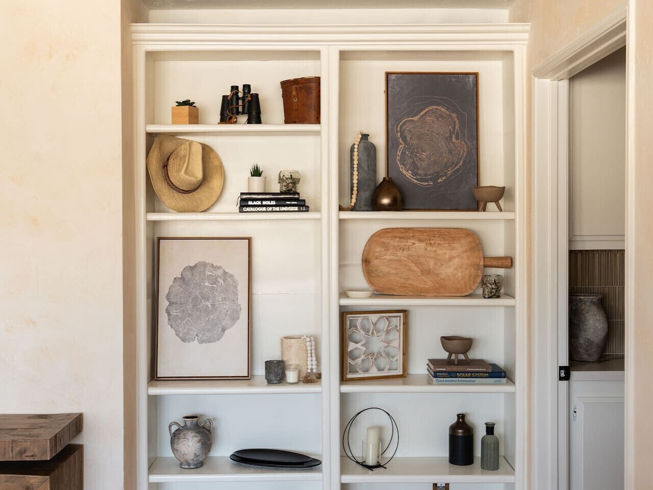 A white built-in shelving unit with various decorative items and books.