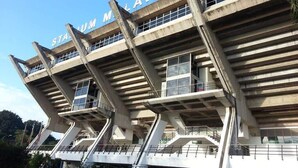 Een stadion met een uniek architectuurontwerp, met meerdere niveaus en balkons.