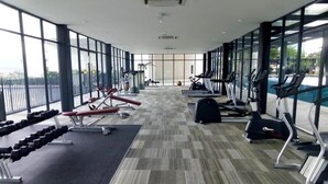 Ein Fitnessstudio mit Laufbändern, Kraftbänken und Kurzhanteln.