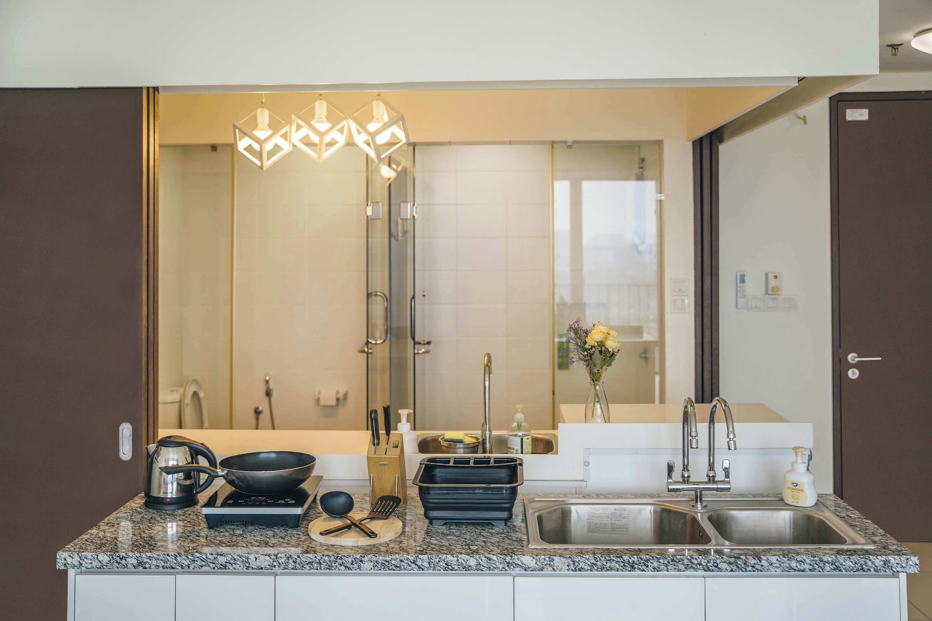 A modern kitchen with granite countertops, a stainless steel sink, and a built-in oven.