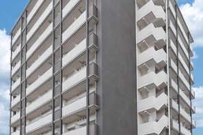A multi-story building with balconies and a clear sky. - FDS Plaisir (Osaka)