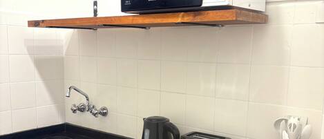 Een microgolfoven, een oven, een kookplaat, een waterkoker