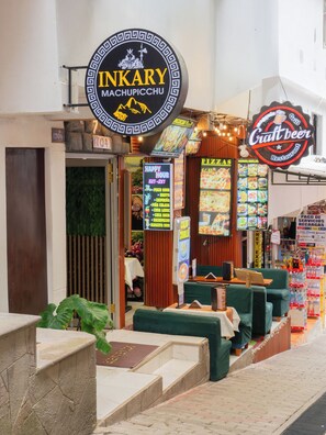 Ein Restaurant namens Inkary mit Schild für Craft Beer, einer Speisekarte und einem grünen Sitzbereich.