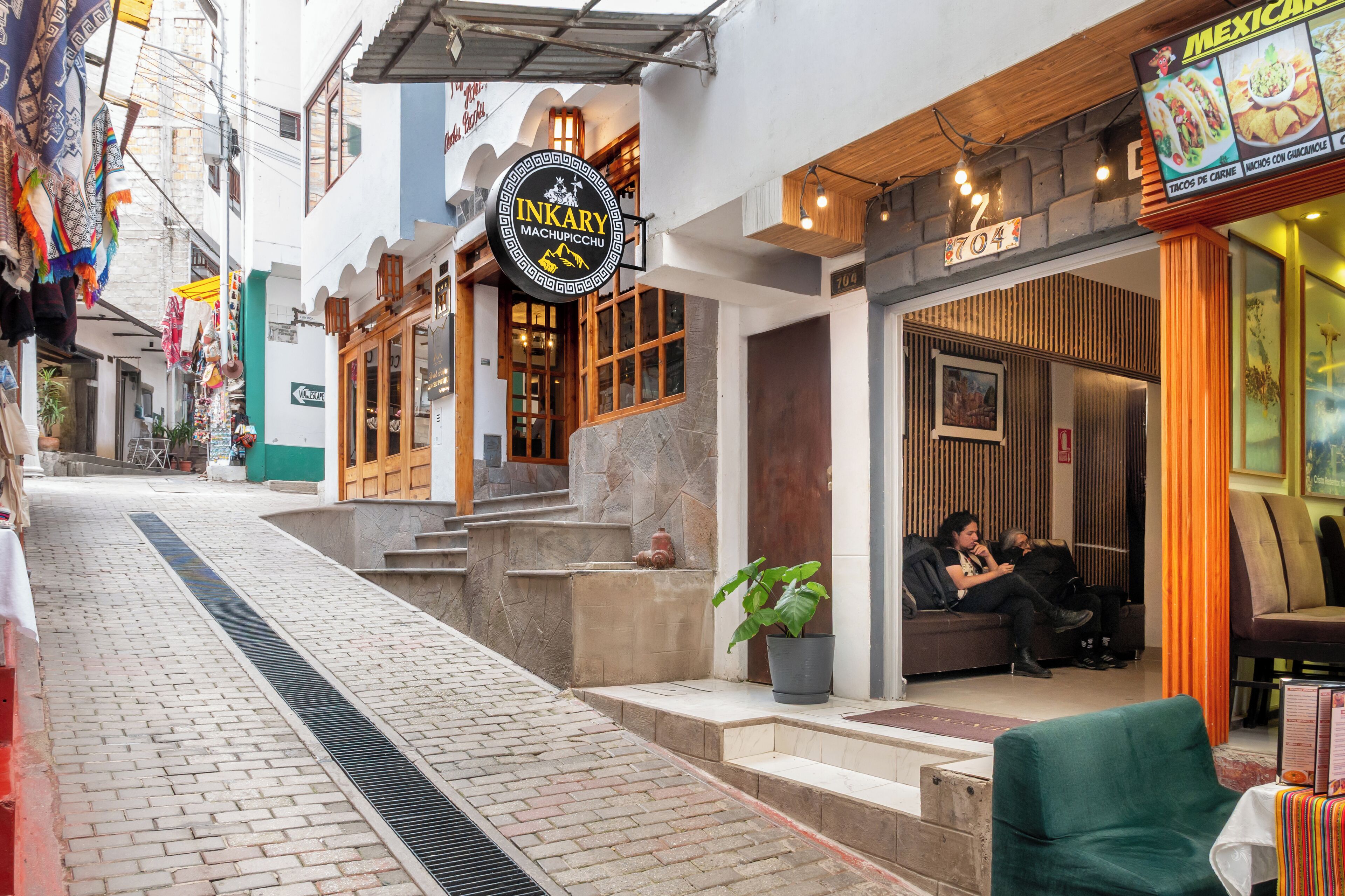 A narrow street with a restaurant named "INKARY MACHUPICCHU" and a sign for "MEXICAN" food.