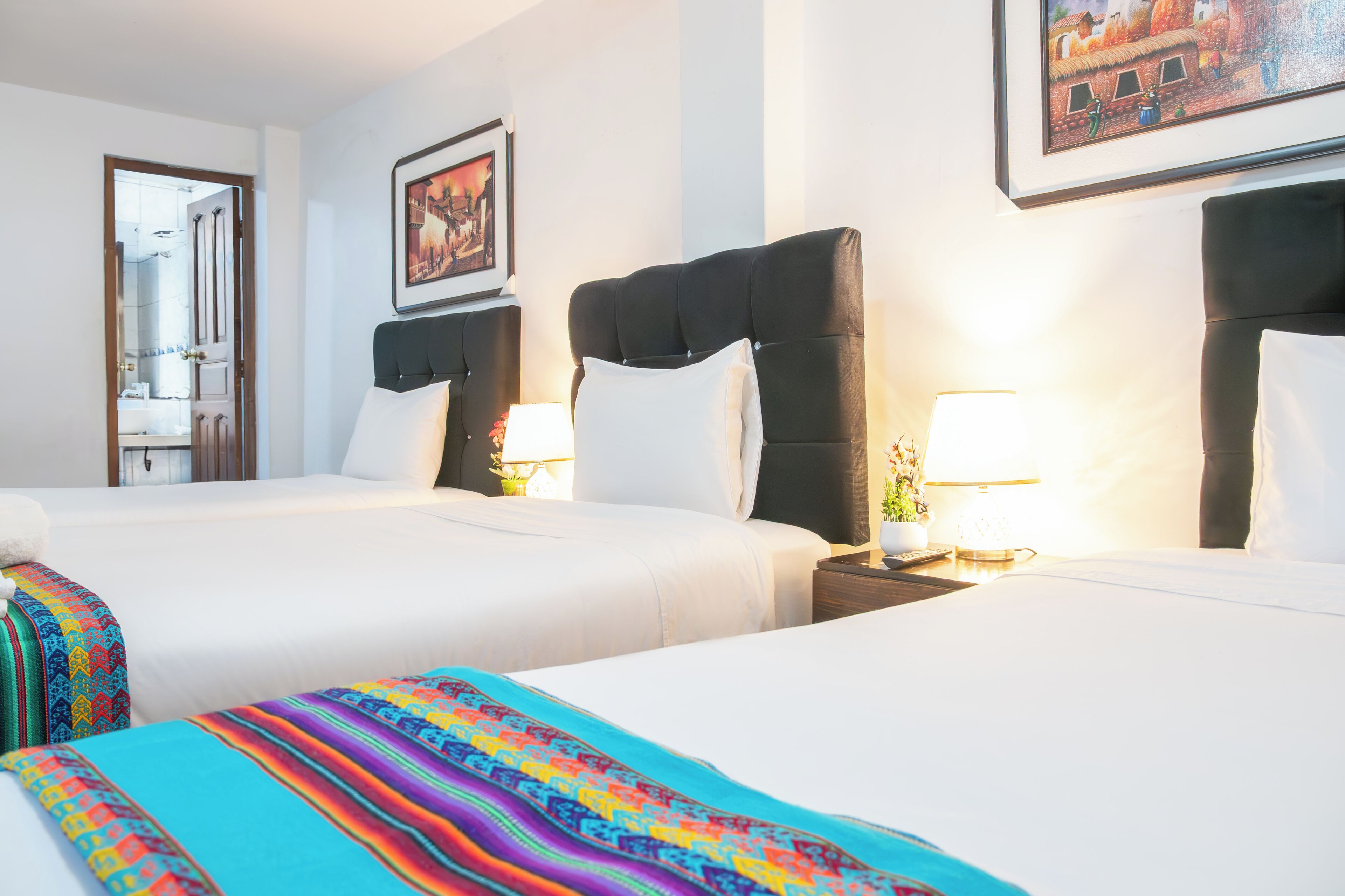 Una habitación de hotel con dos camas, un espejo grande y un cuadro en la pared.
