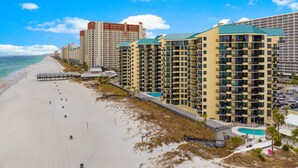 A beachfront hotel with multiple high-rise buildings, a sandy beach, and a clear blue sky. - Beachfront 2BR! · Sunbird 3rd Floor! Free Beach Chairs & Umbrella Service! (Panama City Beach)