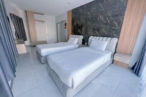 Una habitación de hotel moderna con dos camas, una pared de acento de mármol y vistas a la ciudad.