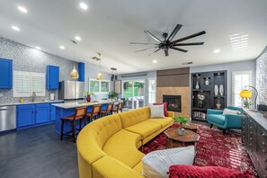 Une cuisine moderne avec des meubles bleus, un canapé jaune et une cheminée.